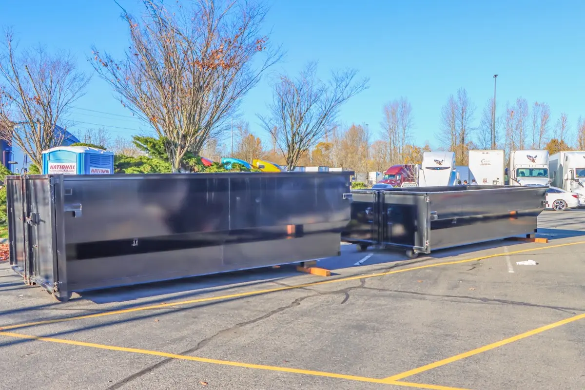 Professional dumpster rental service with roll-off container on residential driveway in Kiryas Joel